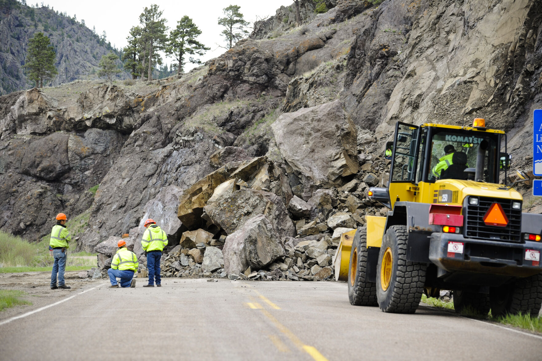 Montana Department of Transportation crews work to clear a substantial rockslide